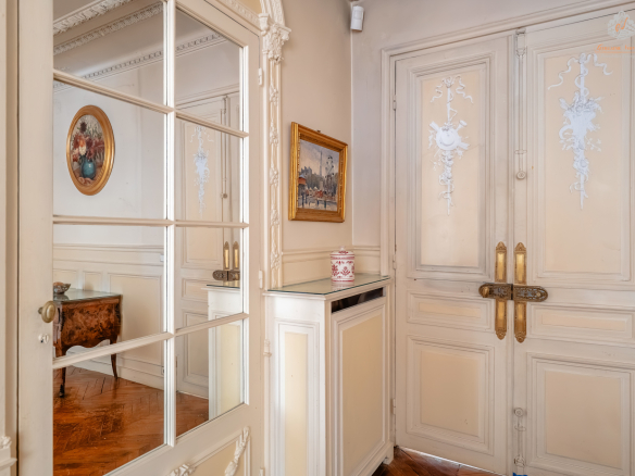 Entrance to an elegant garden level with mirror and decorative doors, Paris 17th.