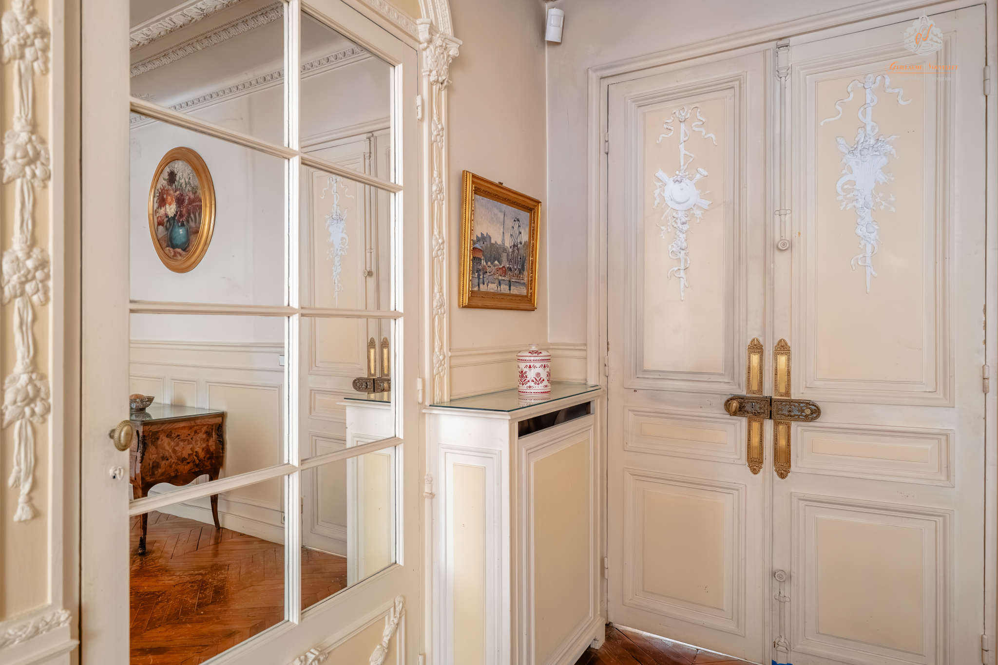 Entrance to a ground-floor apartment in the 17th arrondissement of Paris Entrance to an elegant garden level with mirror and decorative doors, Paris 17th.