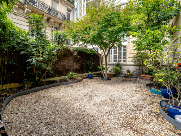 Private garden with trees, gravel, and plants, Paris 17th arrondissement