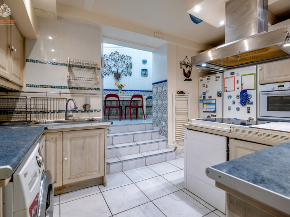Ground floor kitchen in Paris 17th arrondissement, with access to a veranda and dining area.