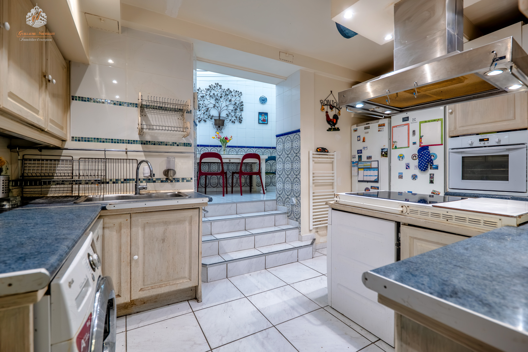 Kitchen on the ground floor of a garden apartment in Paris Ground floor kitchen in Paris 17th arrondissement, with access to a veranda and dining area.