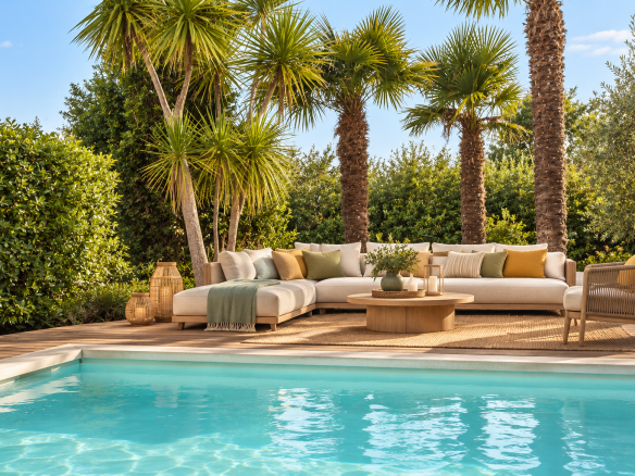 Terrasse avec piscine et salon extérieur, entourée de palmiers et verdure à Bassussarry.