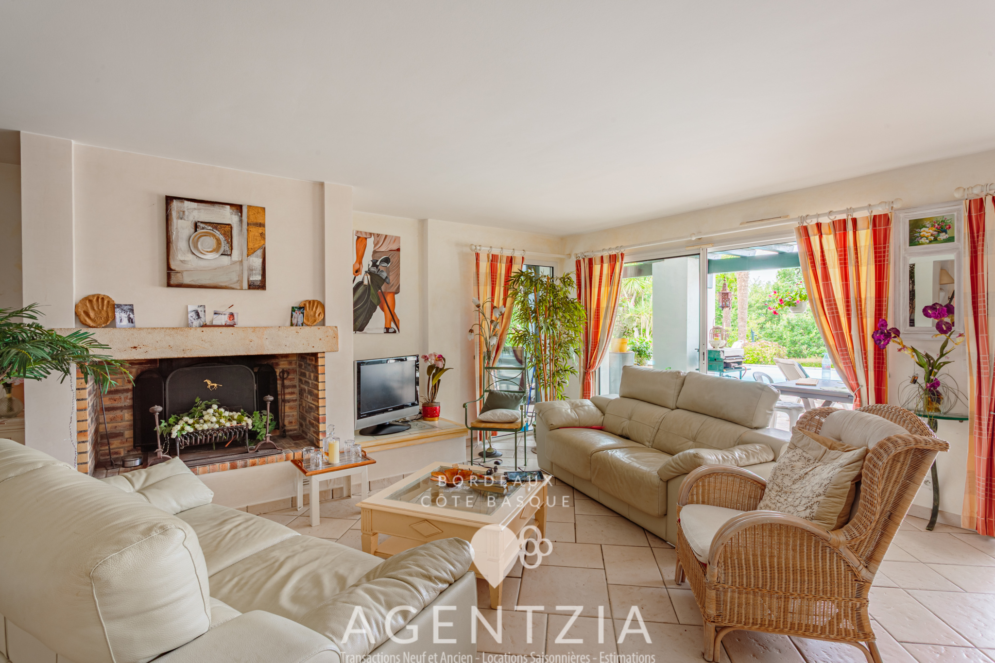 Salon d’une villa à Bassussarry Intérieur d'une villa avec salon lumineux, cheminée et accès au jardin.