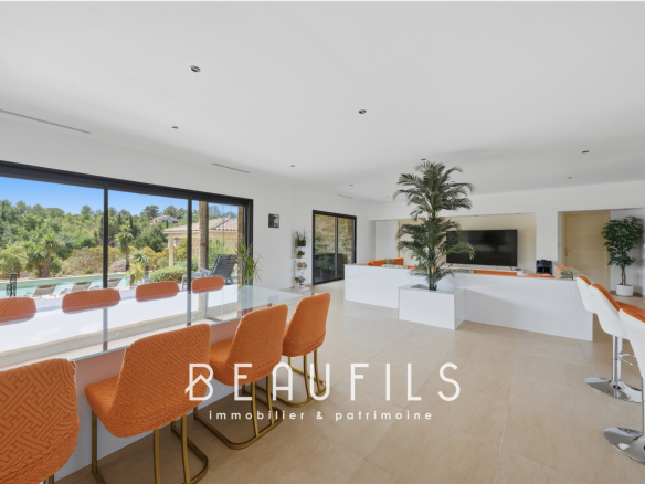 Bright interior of a modern villa with open kitchen and living area, overlooking the garden.
