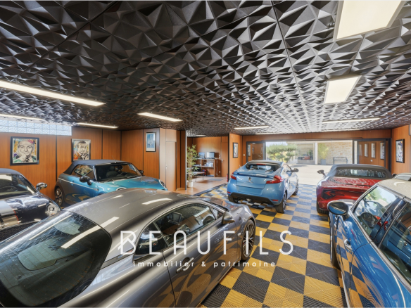 Interior of a spacious garage with several cars, decorated with wooden wall panels and a designer ceiling.