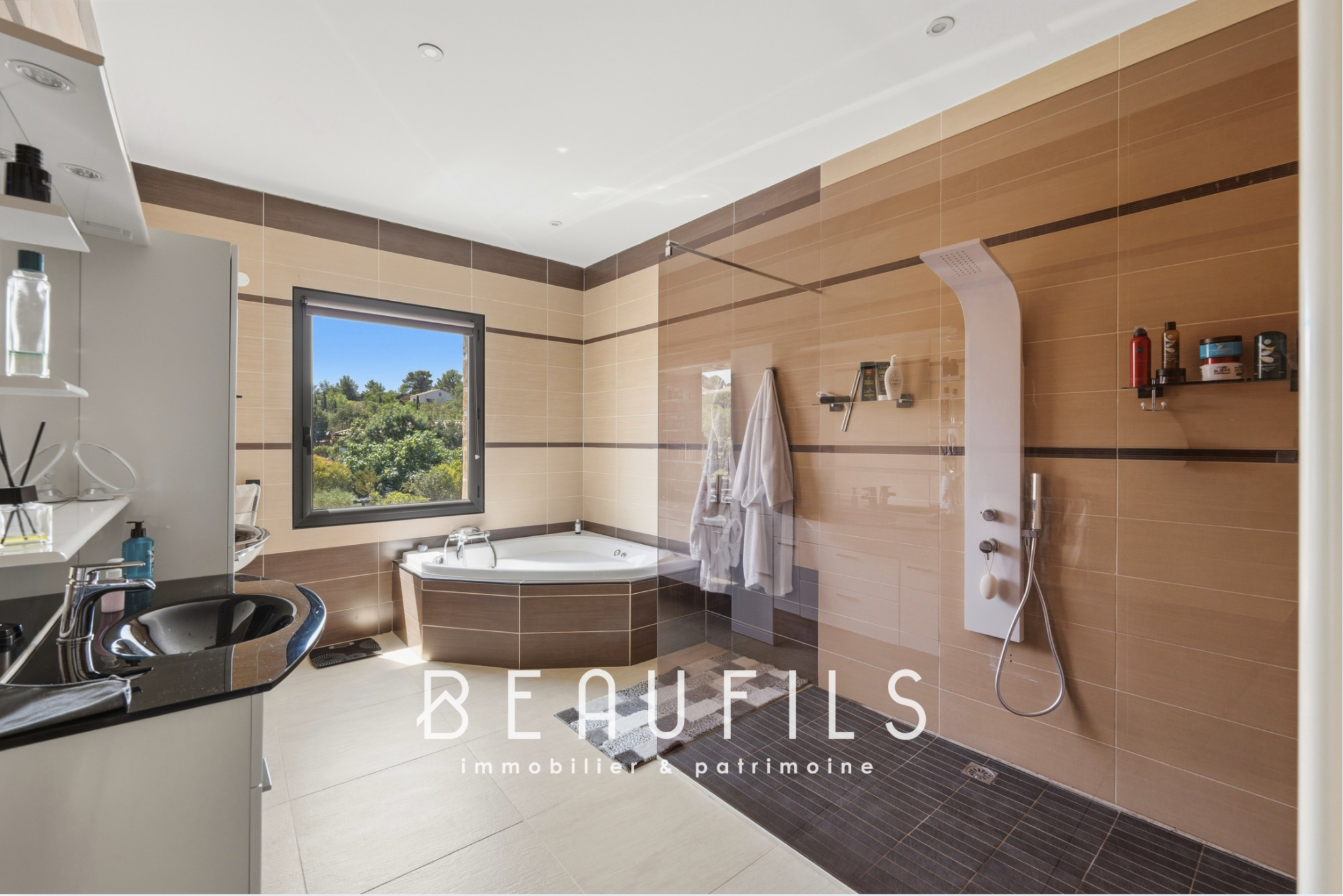 Modern bathroom with bath and shower, window overlooking nature.