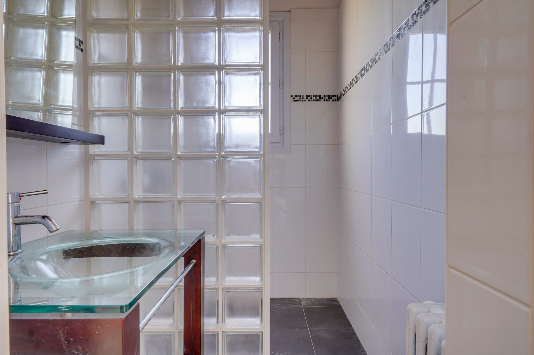 Salle de bain contemporaine Salle de bain moderne avec murs en carreaux de verre et lavabo en verre.