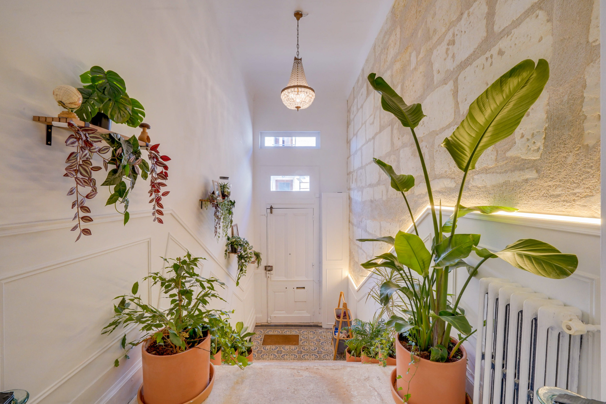 Entrée de maison à Bordeaux Entrée d'une maison avec plantes vertes et murs en pierre à Bordeaux