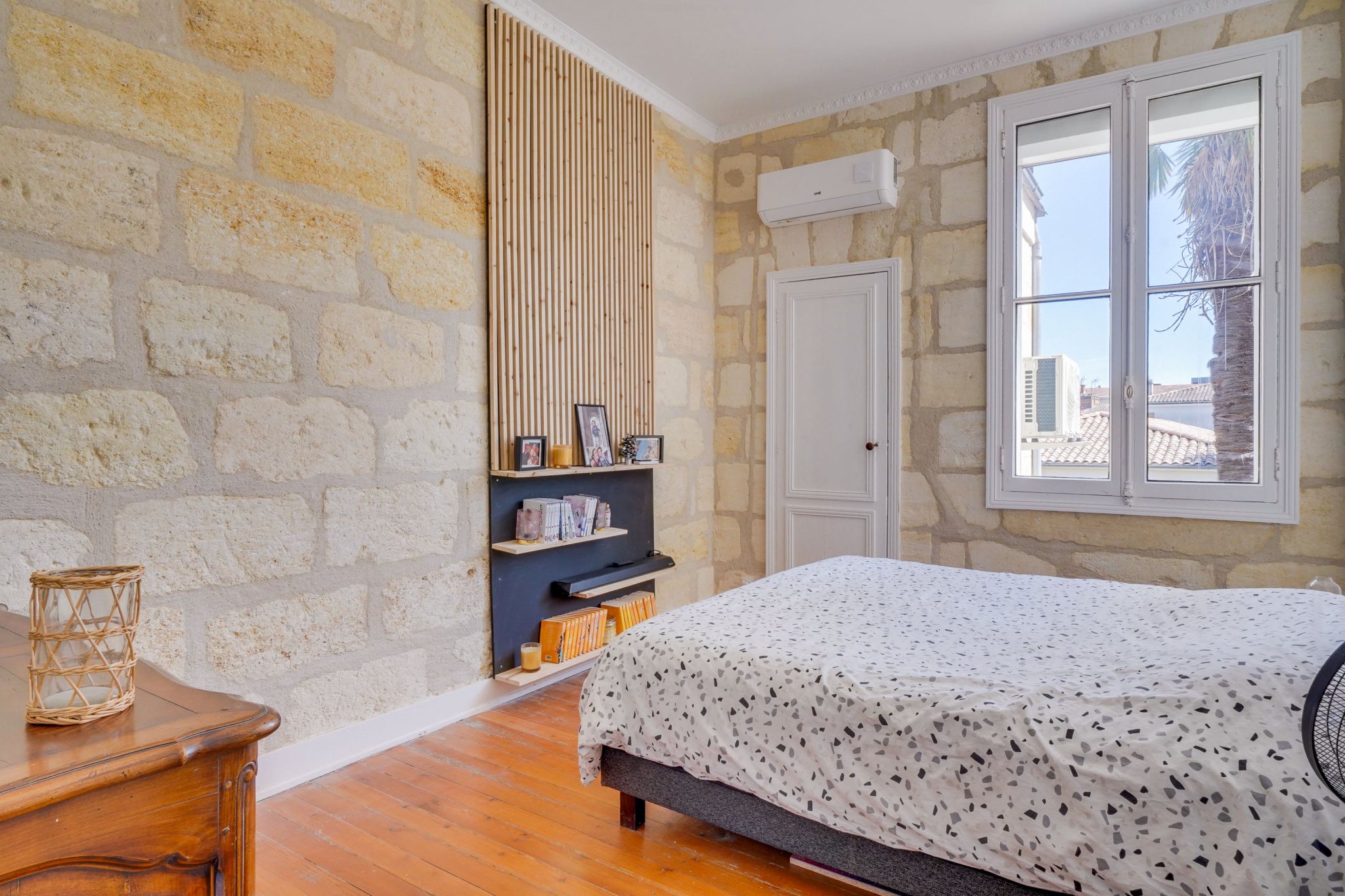 Chambre d’une maison bourgeoise à Bordeaux Chambre dans une maison bourgeoise à Bordeaux, avec murs en pierre et fenêtre.