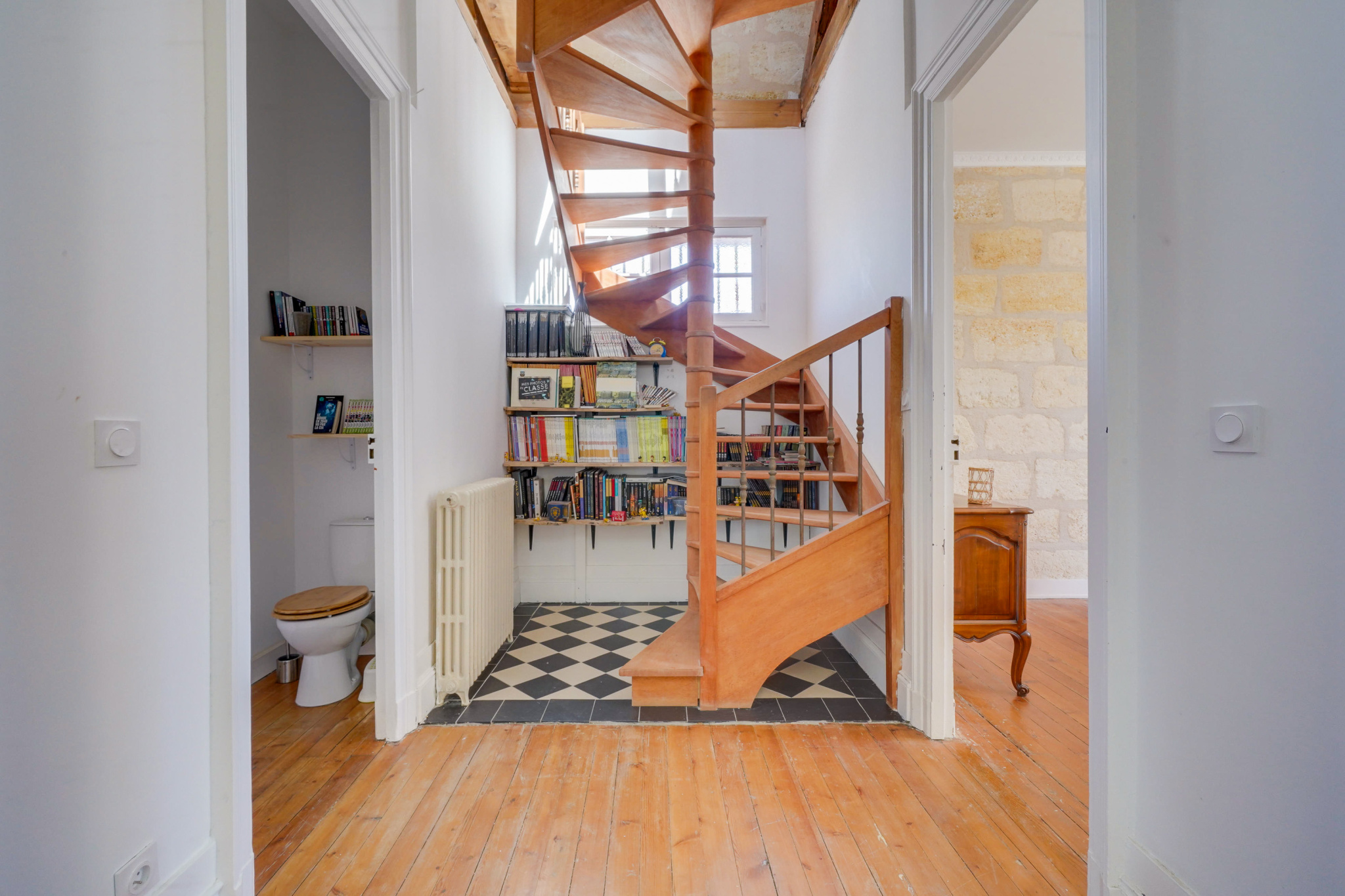 Escalier d’une maison bourgeoise à Bordeaux Intérieur d'une maison bourgeoise à Bordeaux avec un escalier en bois et des murs clairs.