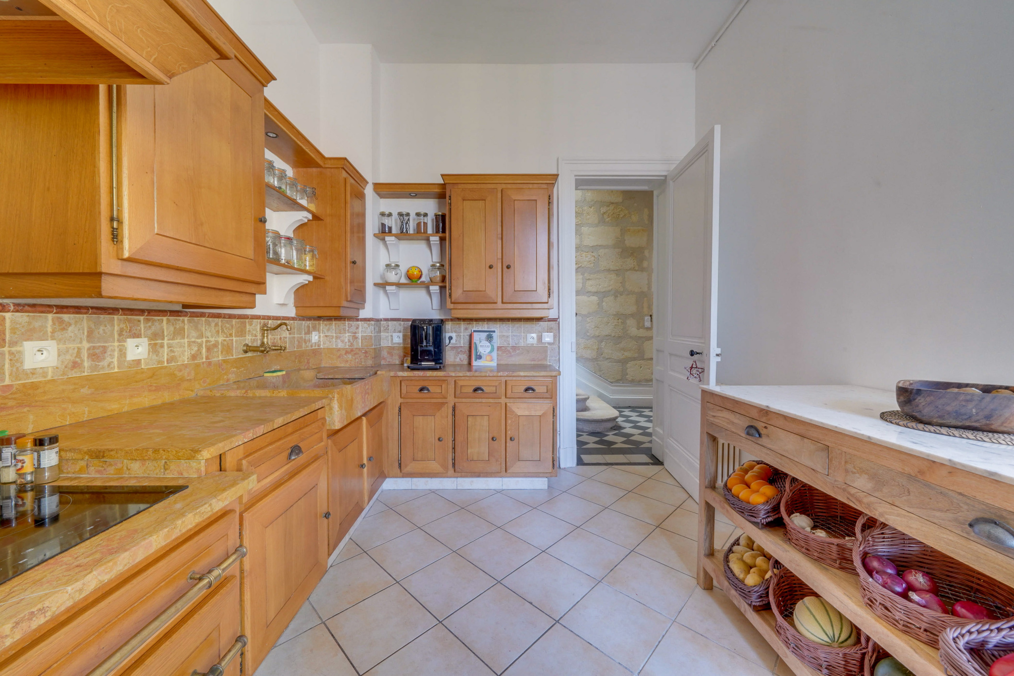 Cuisine d’une maison bourgeoise à Bordeaux Cuisine en bois avec carrelage, équipée de placards et comptoir, dans une maison à Bordeaux.