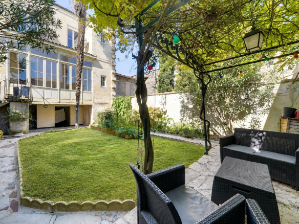 Jardin avec mobilier de jardin et véranda d'une maison à Bordeaux.