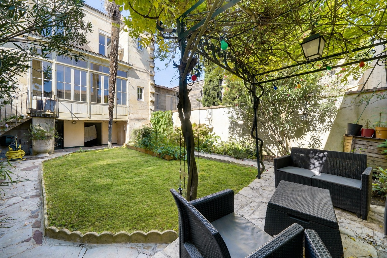 Jardin d’une maison bourgeoise à Bordeaux Jardin avec mobilier de jardin et véranda d'une maison à Bordeaux.