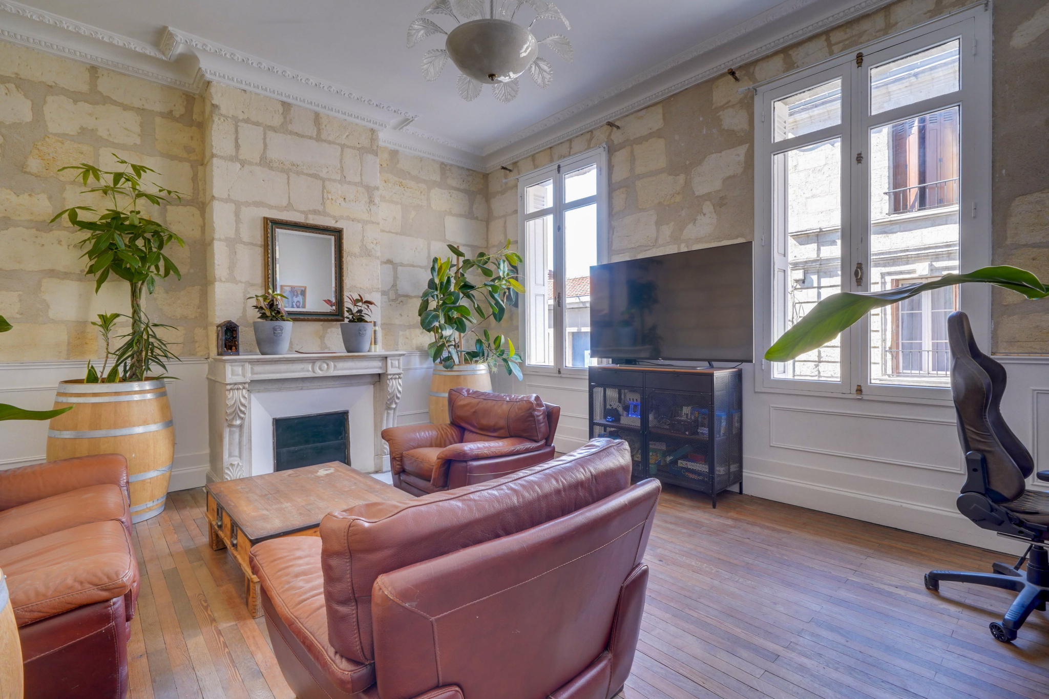 Salon d’une maison bourgeoise à Bordeaux Salon d'une maison bourgeoise à Bordeaux avec murs en pierre et mobilier en cuir.