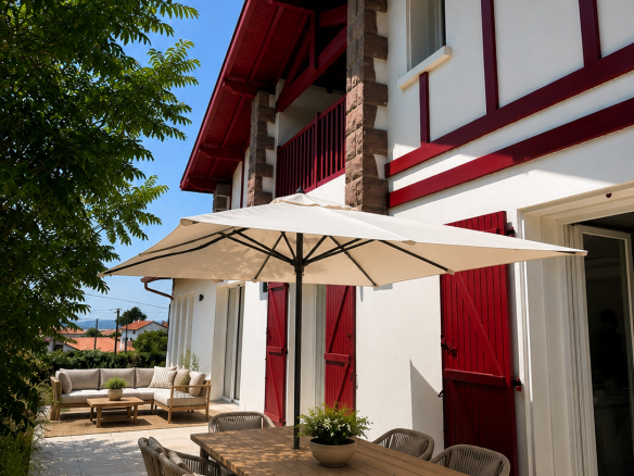 Villa néo Basque à Bidart avec terrasse, mobilier extérieur et parasol.