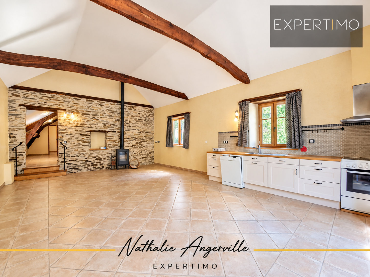 Interior of a property with an old mill Interior of a property with open kitchen and exposed beams, stone walls.