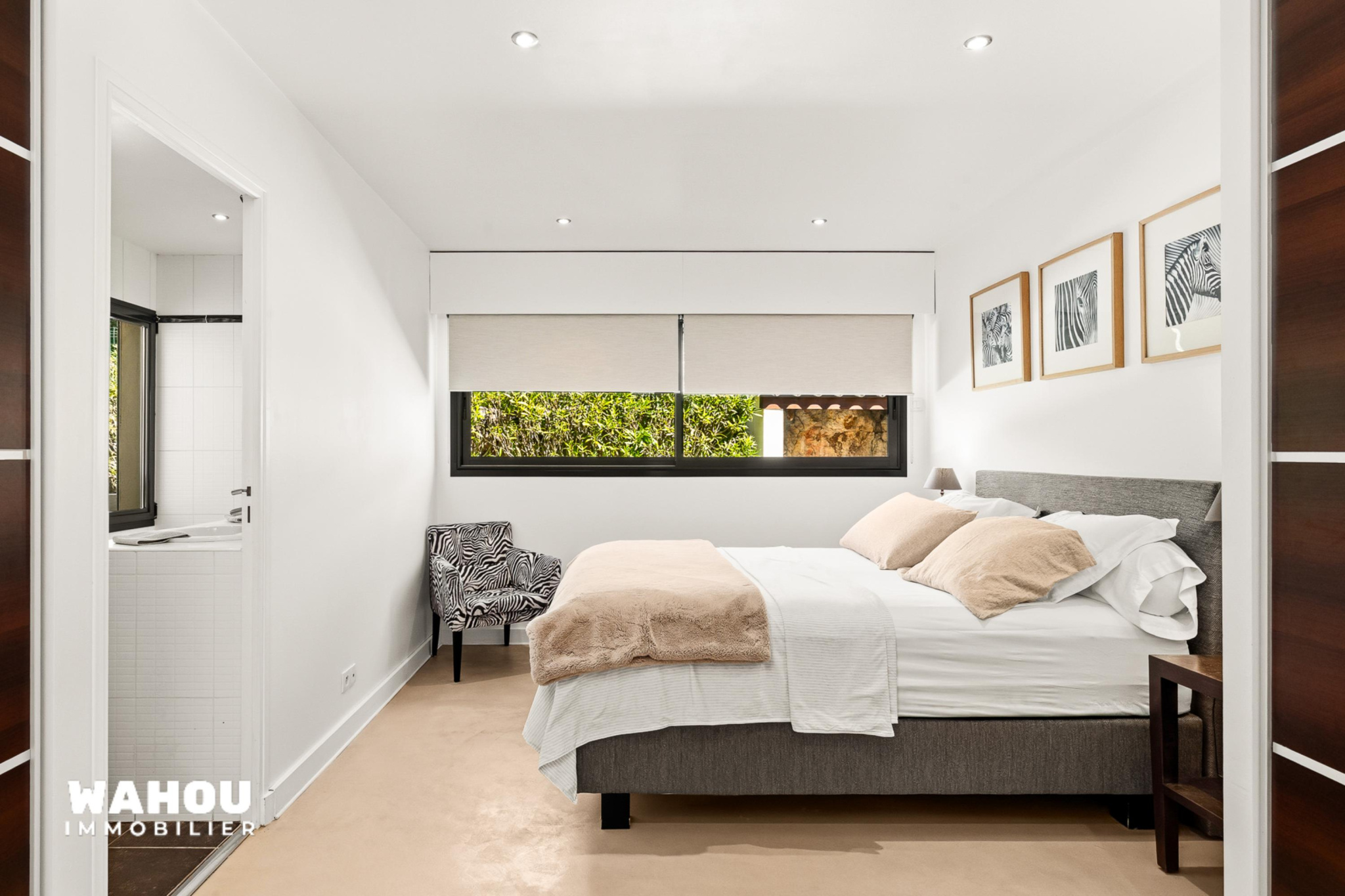 Modern room with double bed and armchair, natural light in Adrets-de-l'Estérel.