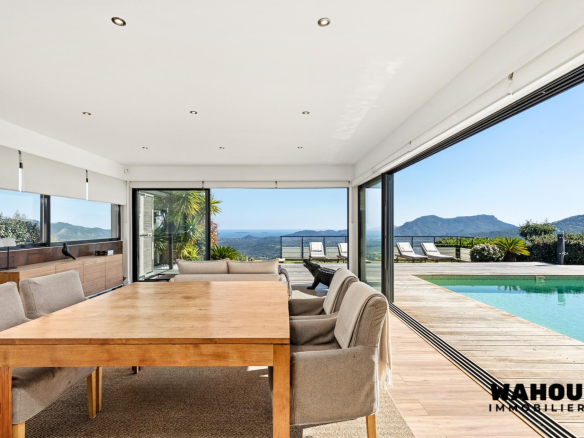 Interior of a modern villa with dining room and view of the Bay of Cannes.