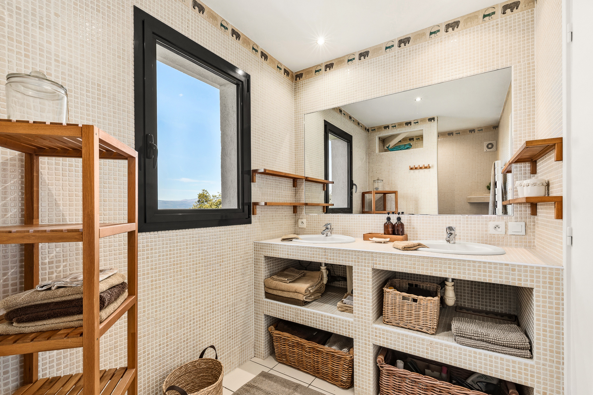 Modern bathroom with double sink and wooden storage, view of the outside.
