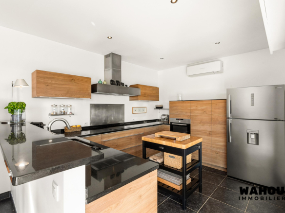 Modern kitchen with granite worktops and wooden furniture in an architect-designed villa.