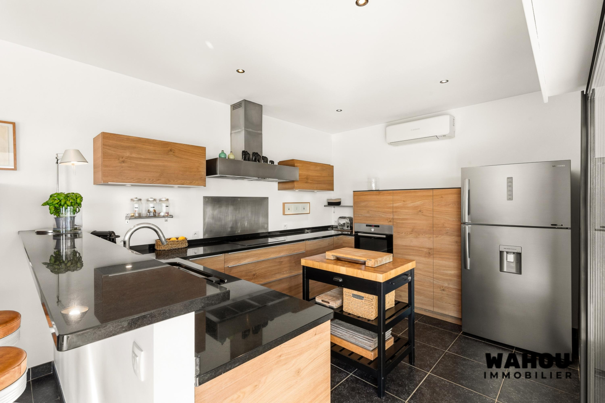 Modern kitchen with granite worktops and wooden furniture in an architect-designed villa.