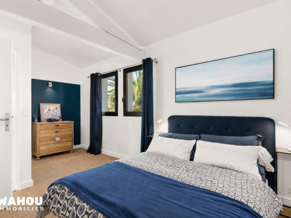 Bedroom in an architect-designed villa with a blue bed and modern decor.