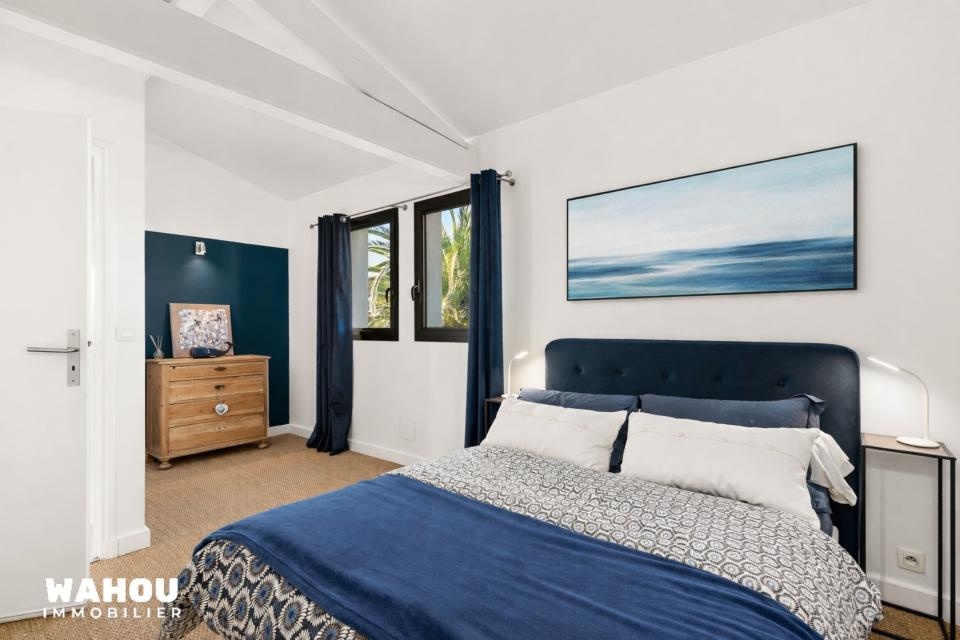 Bedroom in an architect-designed villa with a blue bed and modern decor.