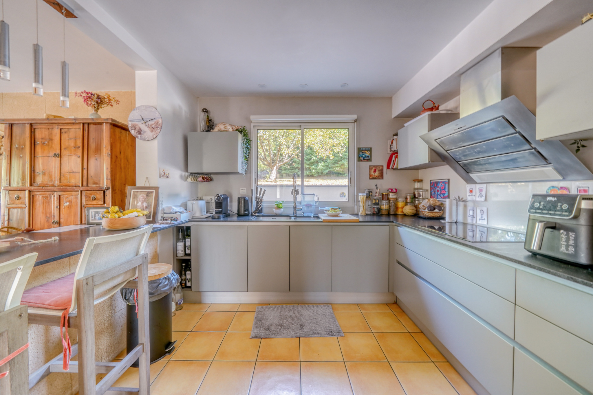Cuisine d’une maison à Montussan Cuisine moderne avec îlot central et équipements intégrés, éclairage naturel