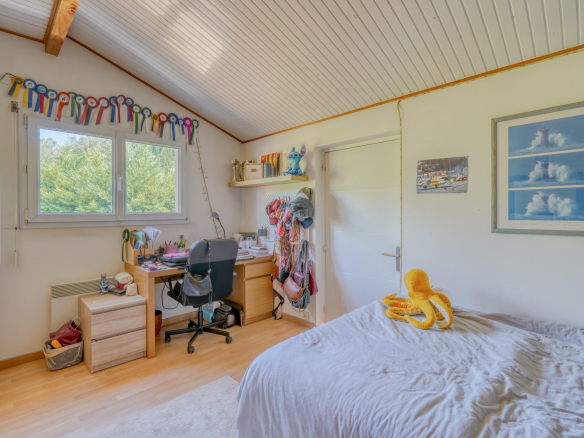 Chambre d'une maison avec bureau, lit et décorations murales à Montussan.