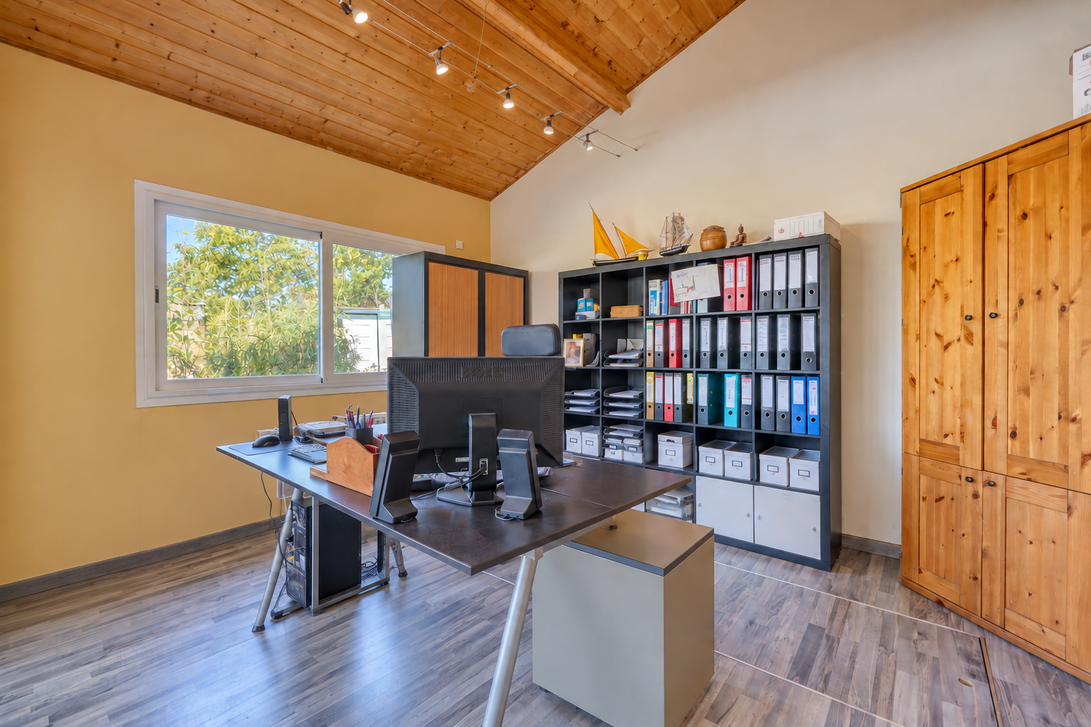 Bureau d’une maison familiale à Montussan Bureau dans une maison avec un bureau en bois et des rangements, fenêtres avec vue sur l'extérieur.