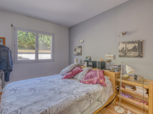 Chambre d'une maison avec lit et étagères, décorée de tableaux.