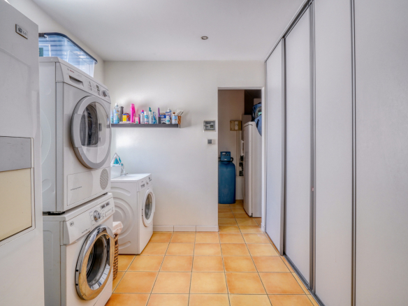 Buanderie avec machines à laver et rangement dans une maison familiale.