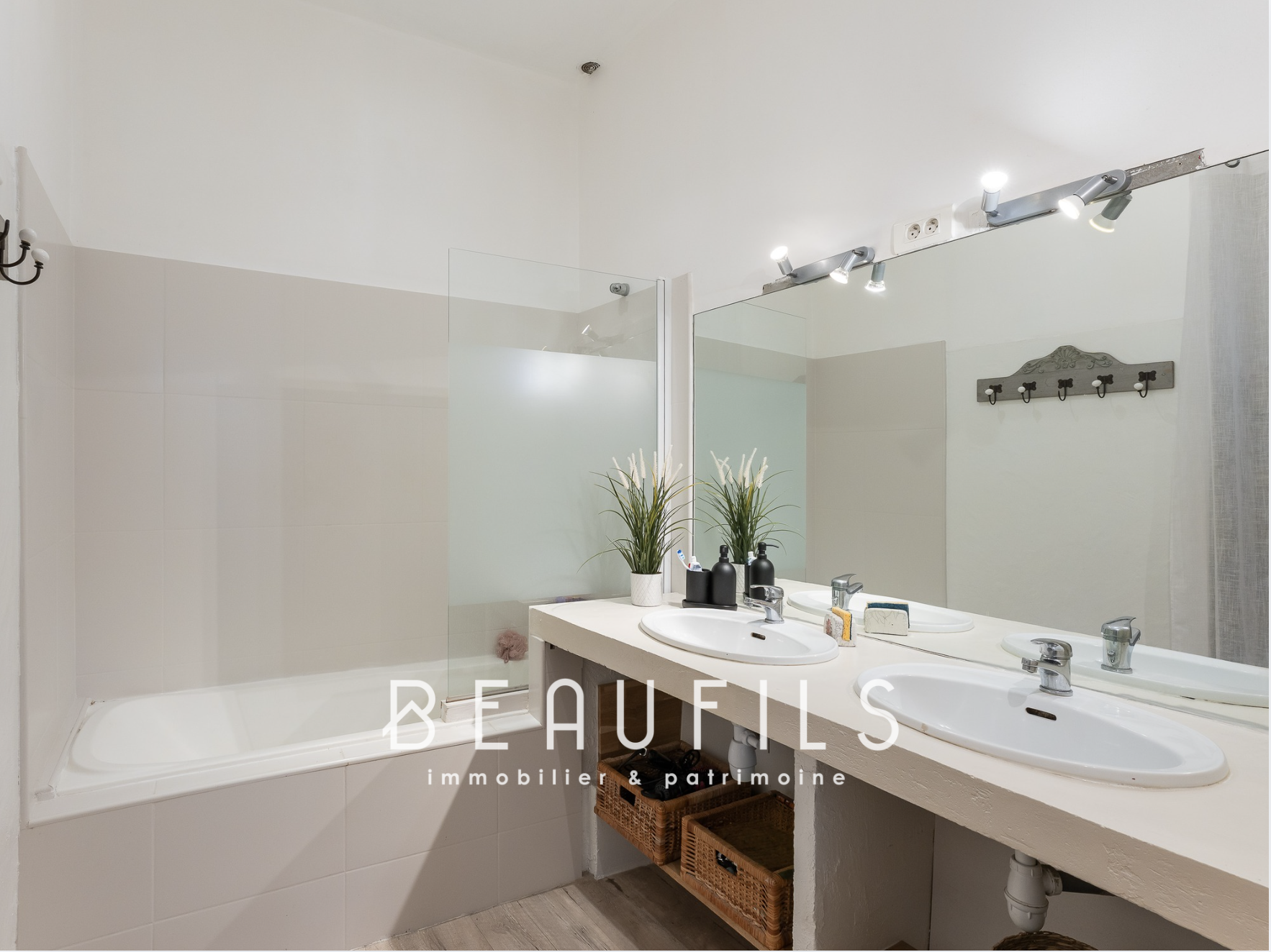 Salle de bain rénovée Salle de bain moderne avec baignoire et double vasque, éclairage au plafond, décoration minimaliste.