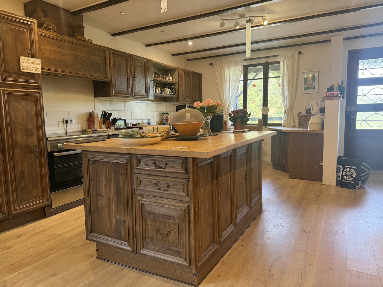 Cuisine spacieuse avec îlot central en bois dans une maison de style ranch.