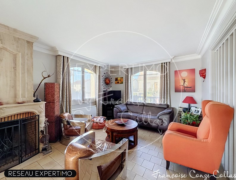 Salon d’une maison à Saint-Cyr-l’École Intérieur d'un salon spacieux avec cheminée, canapé et fauteuils, lumineux.