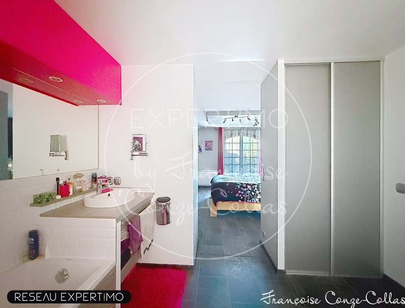 Salle de bain et chambre à coucher Salle de bain moderne avec lavabo et douche, chambre à coucher visible en arrière-plan.