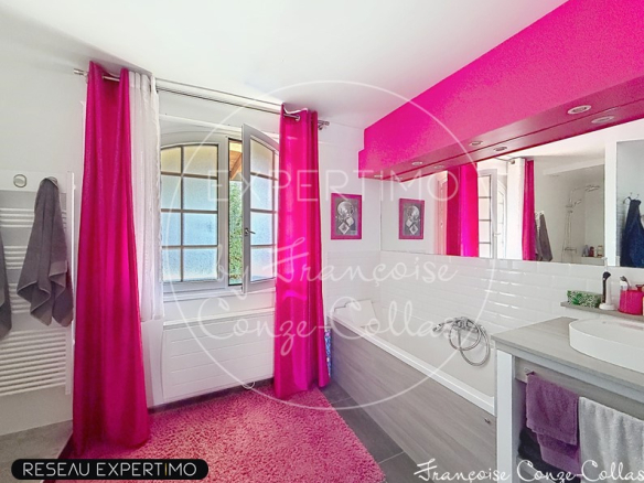 Salle de bain moderne avec rideaux roses et miroir, lumière naturelle.