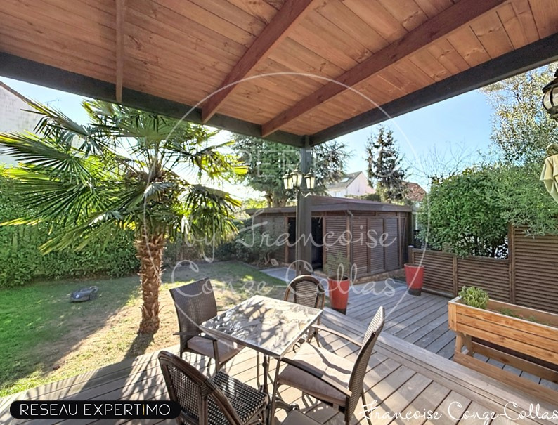 Terrasse en bois avec jardin Terrasse en bois avec mobilier de jardin et palmier, dans un jardin bien entretenu.