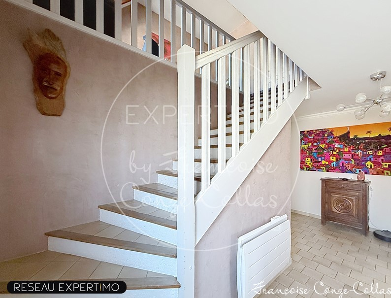 Intérieur d’une maison à Saint-Cyr-l’École Intérieur d'une maison avec un escalier en bois et un mur décoré, éclairage moderne.