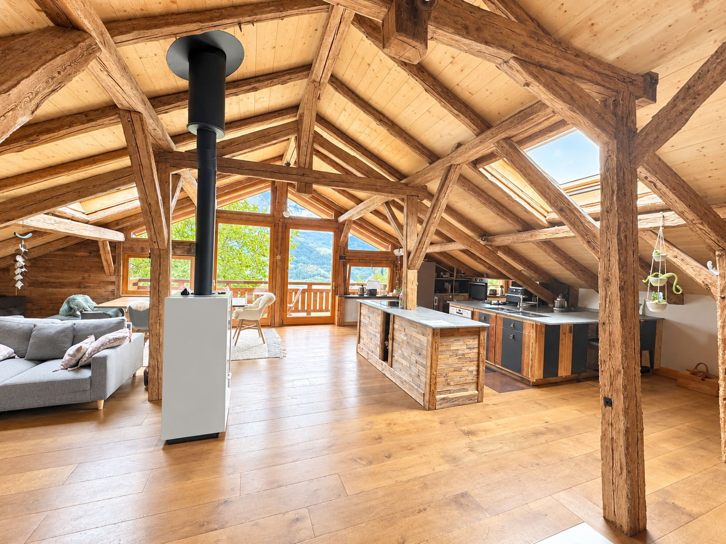 Chalet T5 à Domancy Intérieur d'un chalet T5 à Domancy avec poutres apparentes et cuisine ouverte sur le salon.