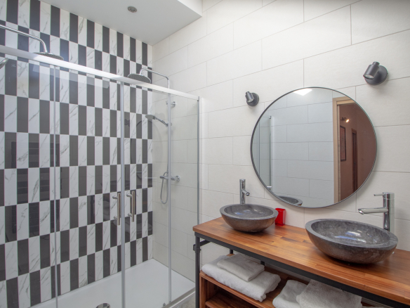 Salle de bain moderne avec douche à l'italienne et double vasque en pierre.