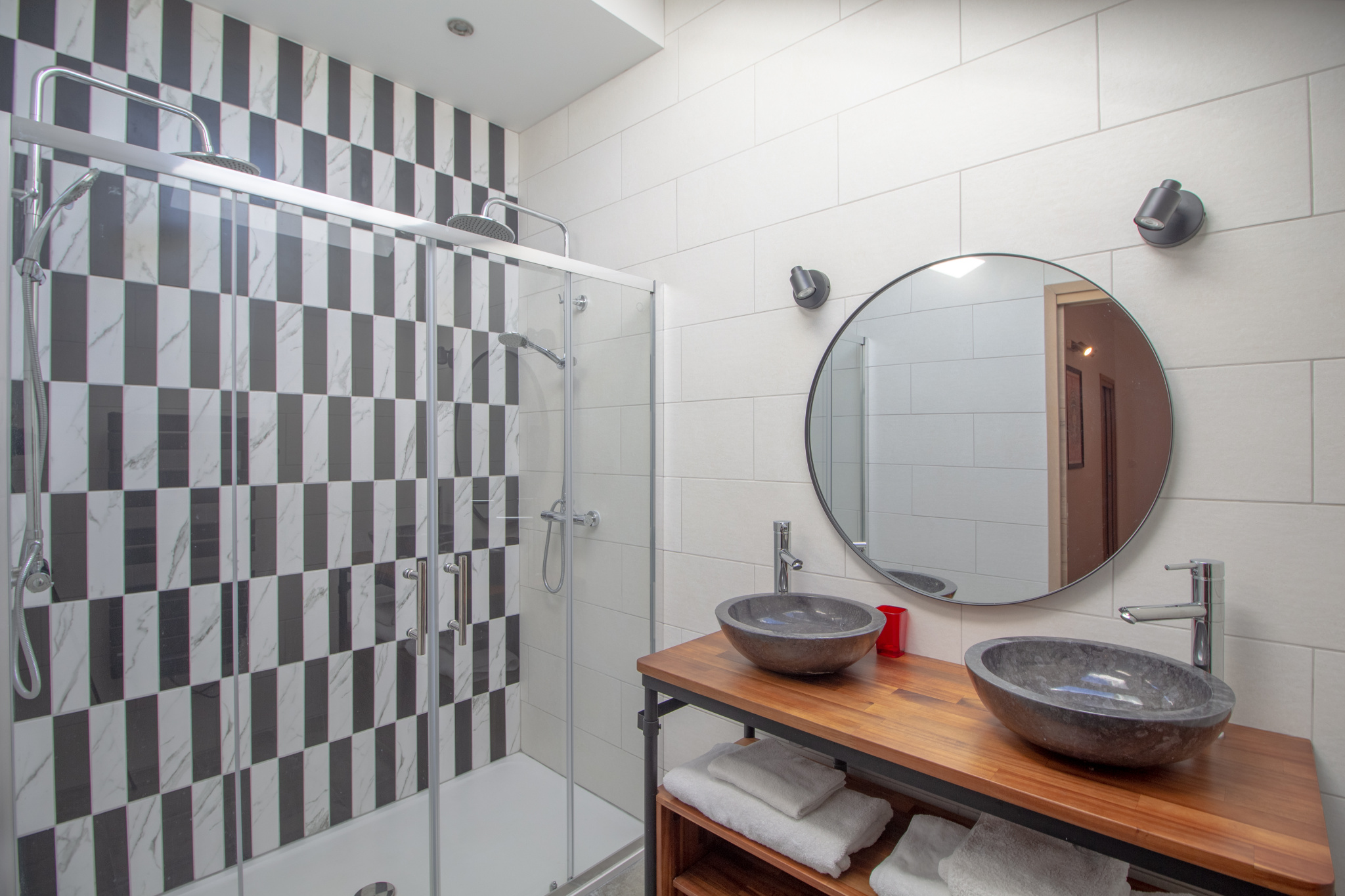 Salle de bain moderne avec douche à l'italienne et double vasque en pierre.