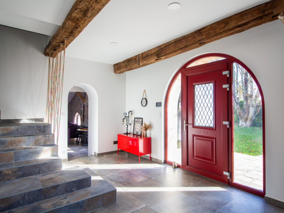 Intérieur d'une maison rénovée avec un hall d'entrée lumineux et des escaliers en pierre.