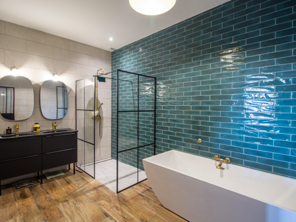 Salle de bain moderne avec baignoire, douche et carrelage bleu à Guiche.
