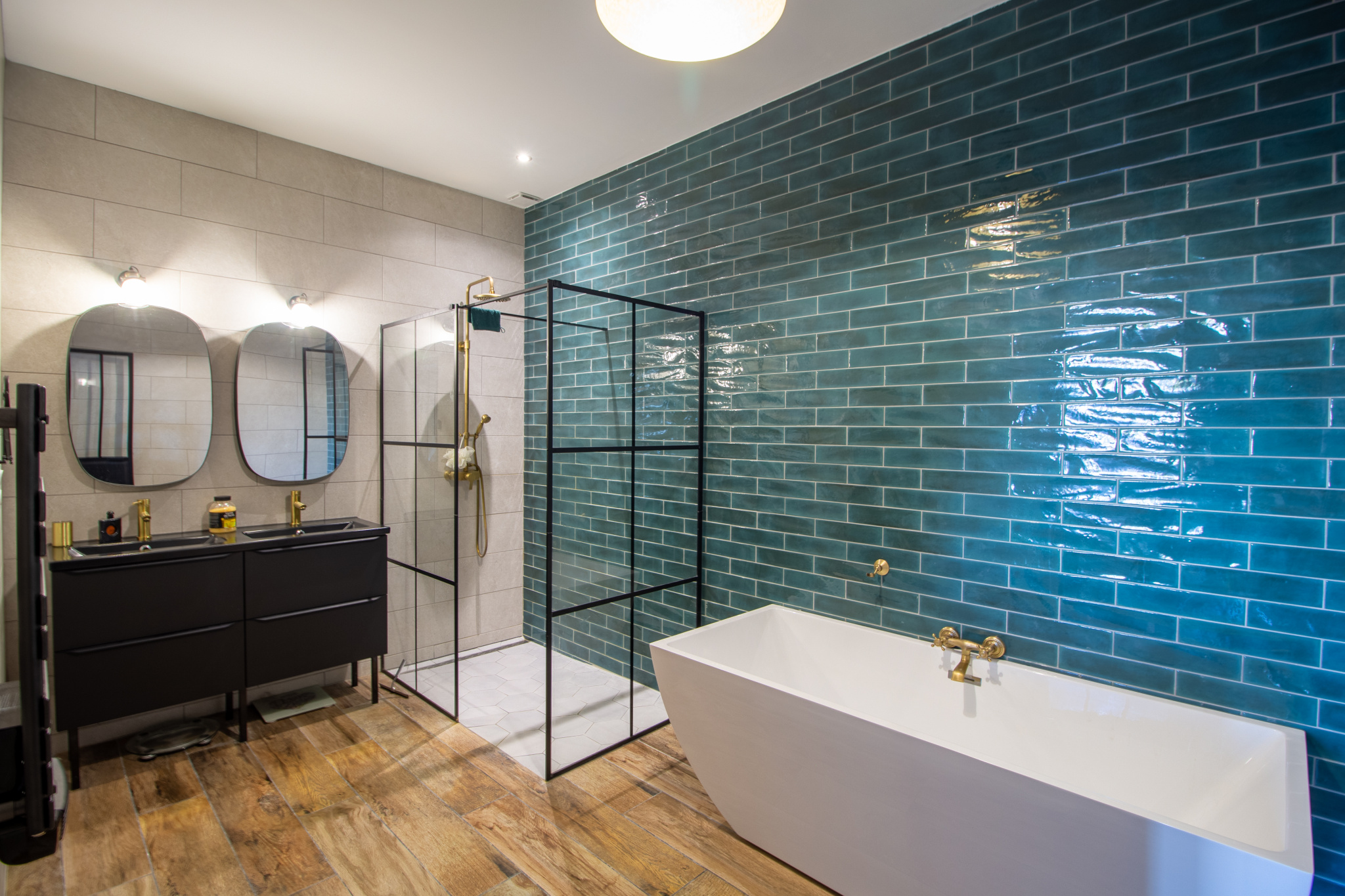 Salle de bain moderne avec baignoire, douche et carrelage bleu à Guiche.