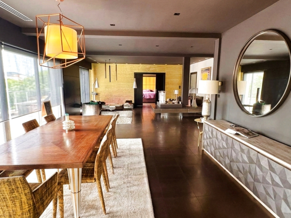 Intérieur d'une villa d'architecte avec salle à manger et salon, décor moderne et lumineux.