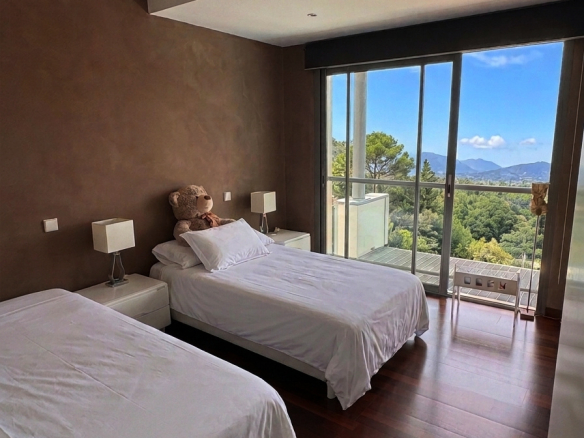 Chambre d'une villa d'architecte avec deux lits simples et vue sur les Pyrénées.