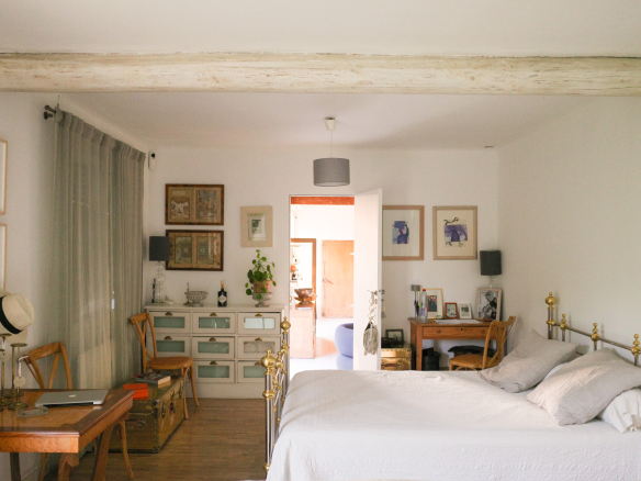 Bedroom in an Art Deco house in L'Isle-sur-la-Sorgue with bed, desk and artistic decoration.