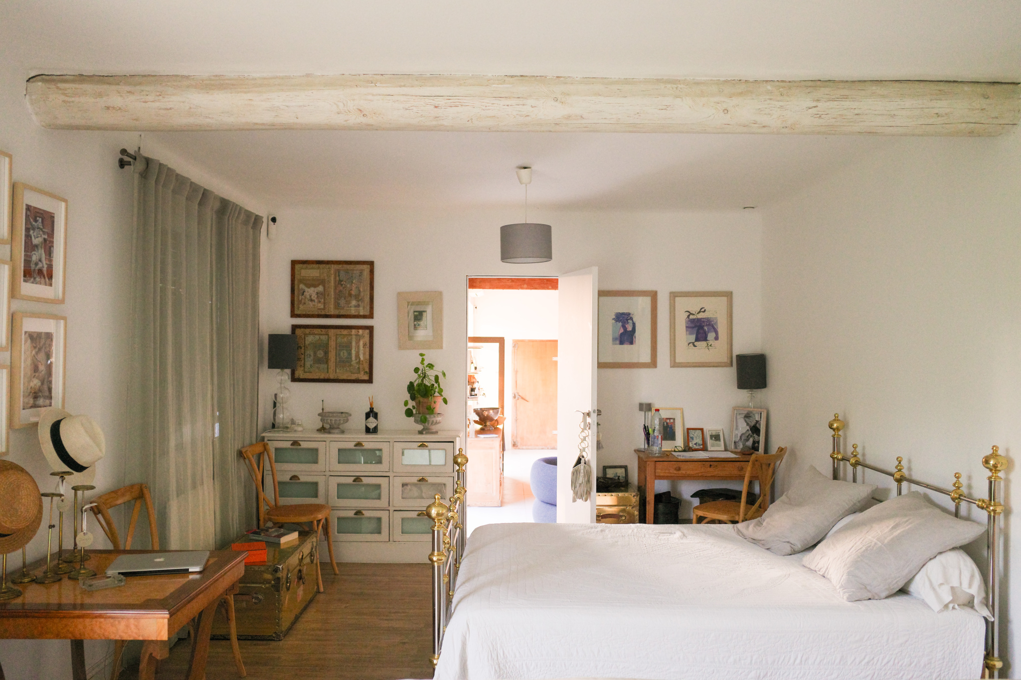 Bedroom in an Art Deco house in L'Isle-sur-la-Sorgue with bed, desk and artistic decoration.