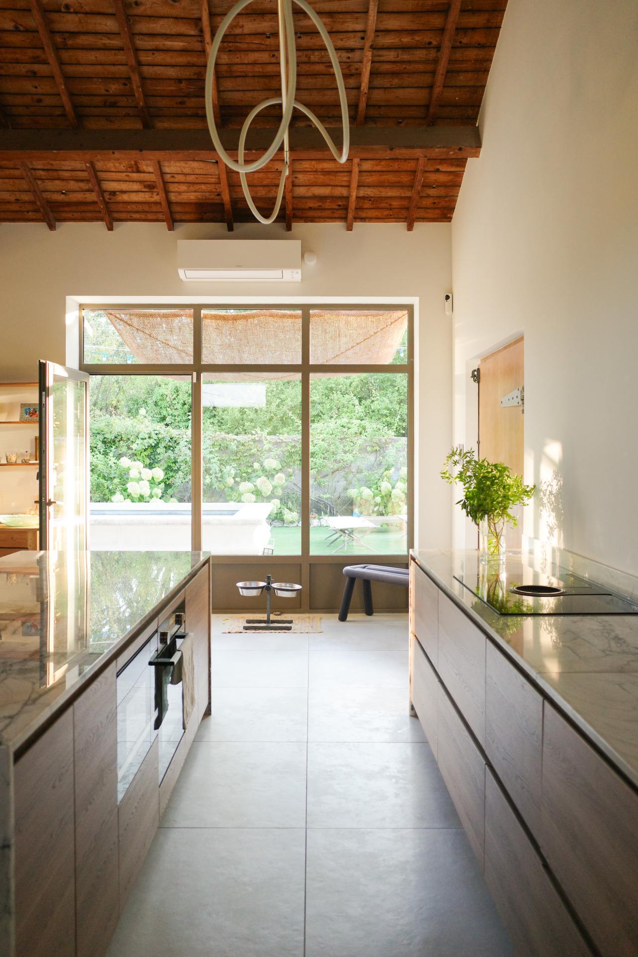 Interior of an Art Deco house with a modern kitchen and large bay windows overlooking a garden.